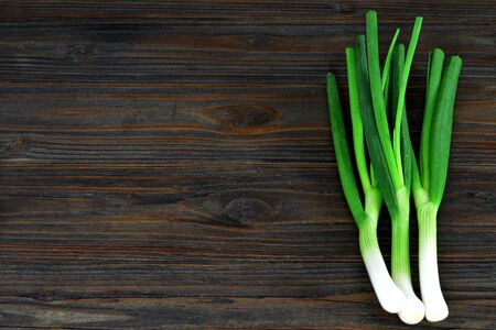 Spring onions on wooden background with copy spaceの写真素材