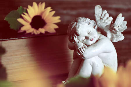 Guardian angel figurine and sunflowersの写真素材