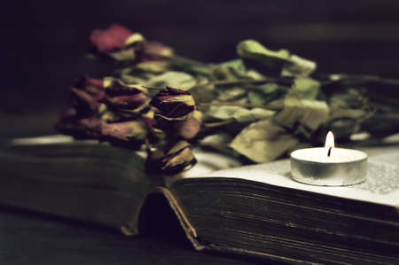Memorial candle, book and dry rosesの写真素材