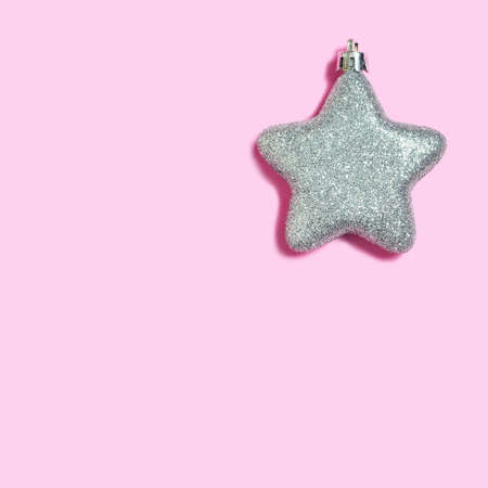 Christmas card with shiny star decoration on pink backgroundの写真素材