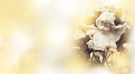 Condolence card with angel sitting in the flower field and reading a bookの写真素材