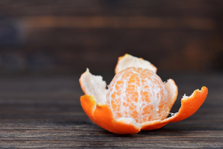Peeled tangerine on wooden background with copy spaceの写真素材