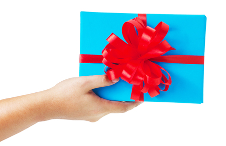 Asian hand giving a gift wrapped in blue box with red ribbon and bow. the most beautiful gift isolated on white backgroundの写真素材