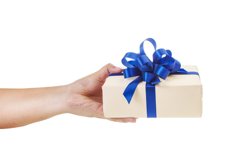 Asian hand giving a gift wrapped in nude color box with blue ribbon and bow. the most beautiful gift isolated on white backgroundの写真素材