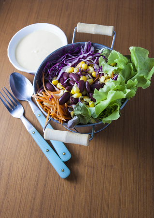 salad on wood background. with carrot, corn, cabbage,violet cabbage, red beans,  Butterhead Lettuceの写真素材
