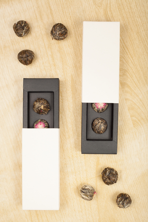 top view of  boxes, exotic green tea flowers balls on wooden floorの写真素材