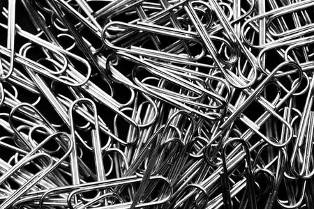 Heap of paper clips - Detail closeup abstract stationery on black clolor backgroundの写真素材