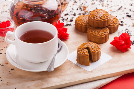 Chinese mid autumn festival foods. Traditional mooncakes on table setting with teacup.の写真素材