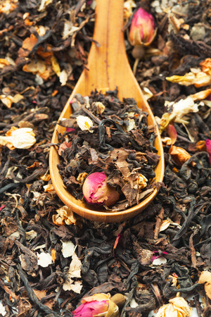Close up of dry tea in wooden spoons over heap of tea.Selective focus on blurry backgroundの写真素材