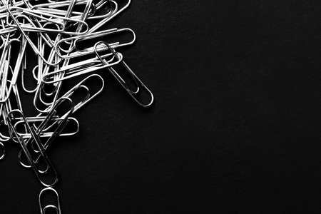 Heap of paper clips - Detail closeup abstract stationery on black clolor background. with copy spaceの写真素材