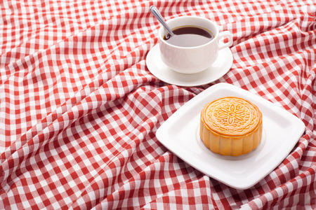 Chinese mid autumn festival foods. Traditional moon cakes on table setting with teacup.の写真素材