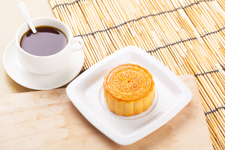 Chinese mid autumn festival foods. Traditional moon cakes on table setting with teacup.の写真素材