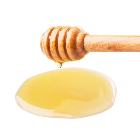 Honey dripping from a wooden dipper on isolate white background. ready to use with clipping path.の写真素材