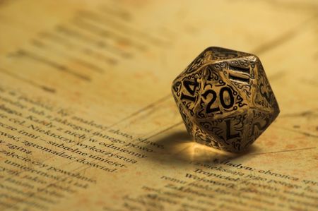 Embellished K20 dice laying on role playing game bookの写真素材