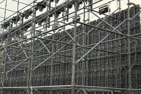 In the winter of 2025, the support frame behind a large electronic display screen in a city square...