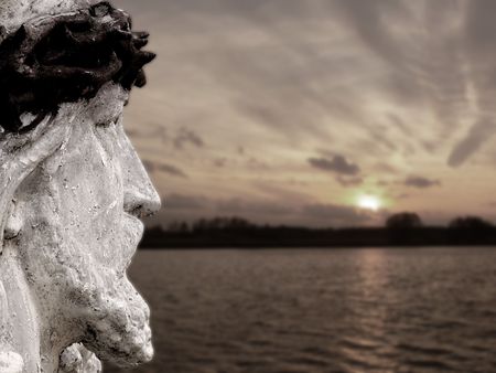 Statue of Jesus against sunset skyの写真素材