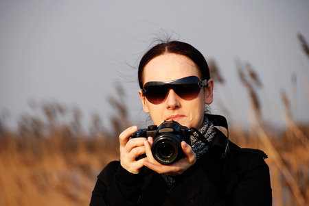 A young woman taking photos outside