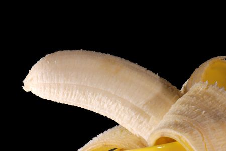 Half-peeled banana on black backgroundの写真素材