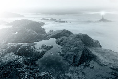 Coastal landscape with a lighthouse in the distance
