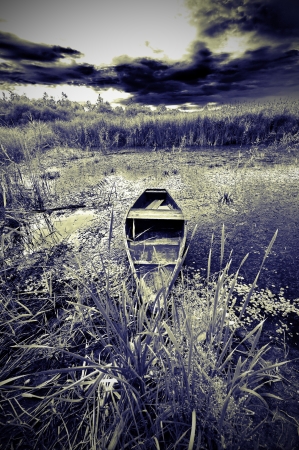 Infrared landscape with boat on a lakeの写真素材