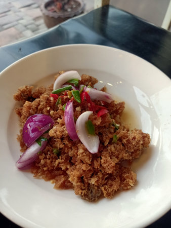 Spicy minced pork salad with red onion and chili on white plateの写真素材