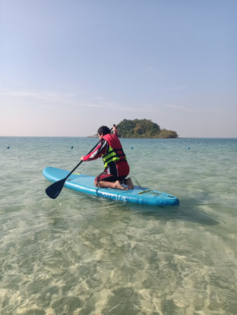 Young man paddling on a stand up paddleboard in the seaの写真素材