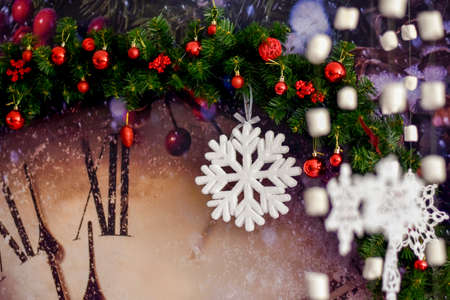 big white Christmas snowflake on the background of a large clock with Christmas tree branches and Christmas toysの写真素材