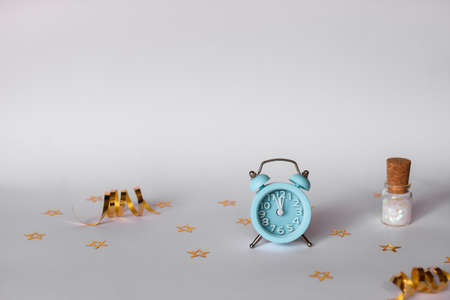 Christmas composition. Blue alarm clock, Golden snowflakes, layout on a white background. Place for an inscription.の写真素材