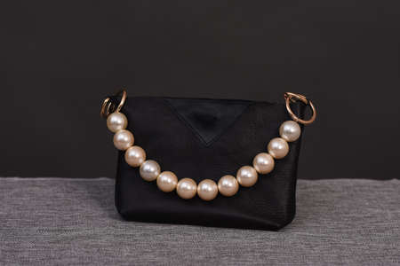 Black bag with pearl handles on a gray backgroundの写真素材