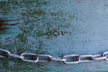 Old texture with damaged paint with a metal chain. Texture in green.の写真素材