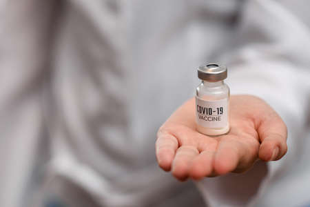 Coronavirus vaccine in the palm of a doctor, nurse. Research and testing of a drug for covid-19.の写真素材