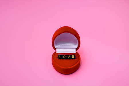 Gift case for a ring in the form of a red heart. It contains the word love in letters on cubes.の写真素材