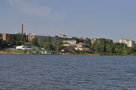 A city on the shore of a lake. Water in the foreground.の写真素材