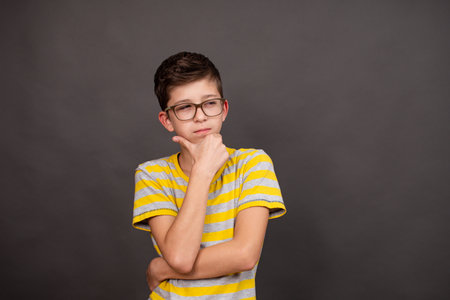 boy with glasses. thoughtful look. on a dark gray background.の写真素材