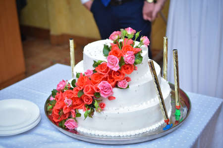 A large beautiful wedding cake is decorated with rose flowers.の写真素材