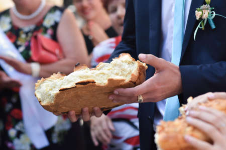 The groom tore a piece from the wedding loaf.の写真素材