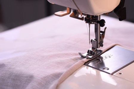 The process of sewing on a sewing machine.