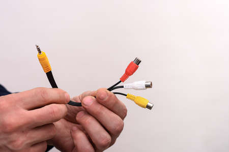 Audio video cable RCA jack in a mans hands on a white background.の写真素材