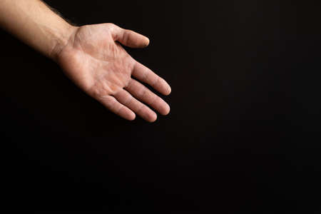 a mans hand on a black background.の写真素材