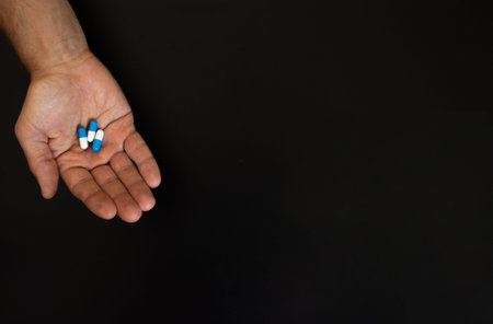 on the palm of an adult man are three tablets.