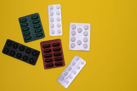 Blister packs of tablets and capsules in different colors.