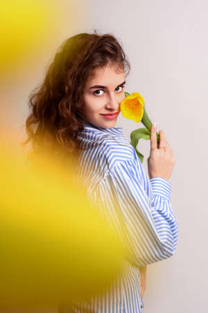 A girl with a yellow flower on a white backgroundの写真素材