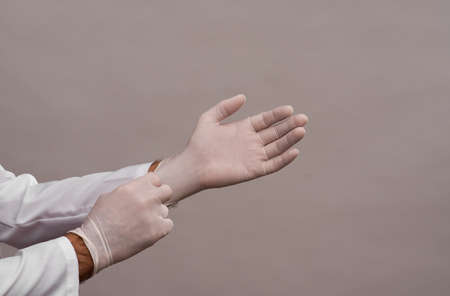 the doctor puts on disposable rubber protective gloves.の写真素材
