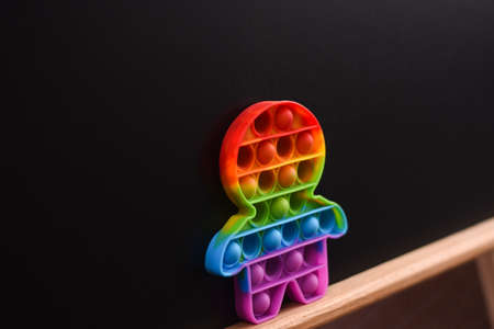 Fidget toy on a black background. on a wooden plank.の写真素材