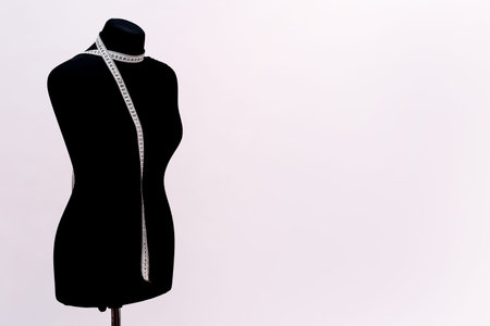 black mannequin for sewing clothes with a measuring tape.