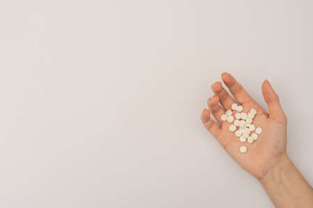 handful of white pills in the palm of your hand. copy spaceの写真素材