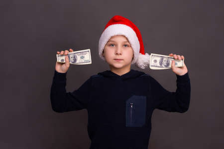 the boy holds two bundles of dollars in his hands.の写真素材