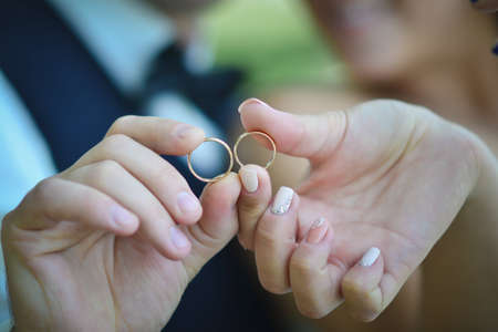 wedding rings in the hands of the bride and groomの写真素材