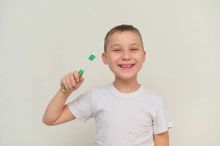 a smiling boy holds a toothbrush in his hand. mock upの写真素材