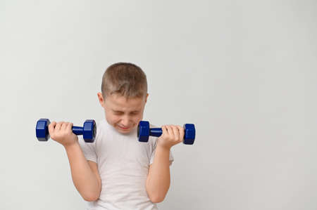 a boy 8-10 years old with dumbbells on a white background. mock upの写真素材